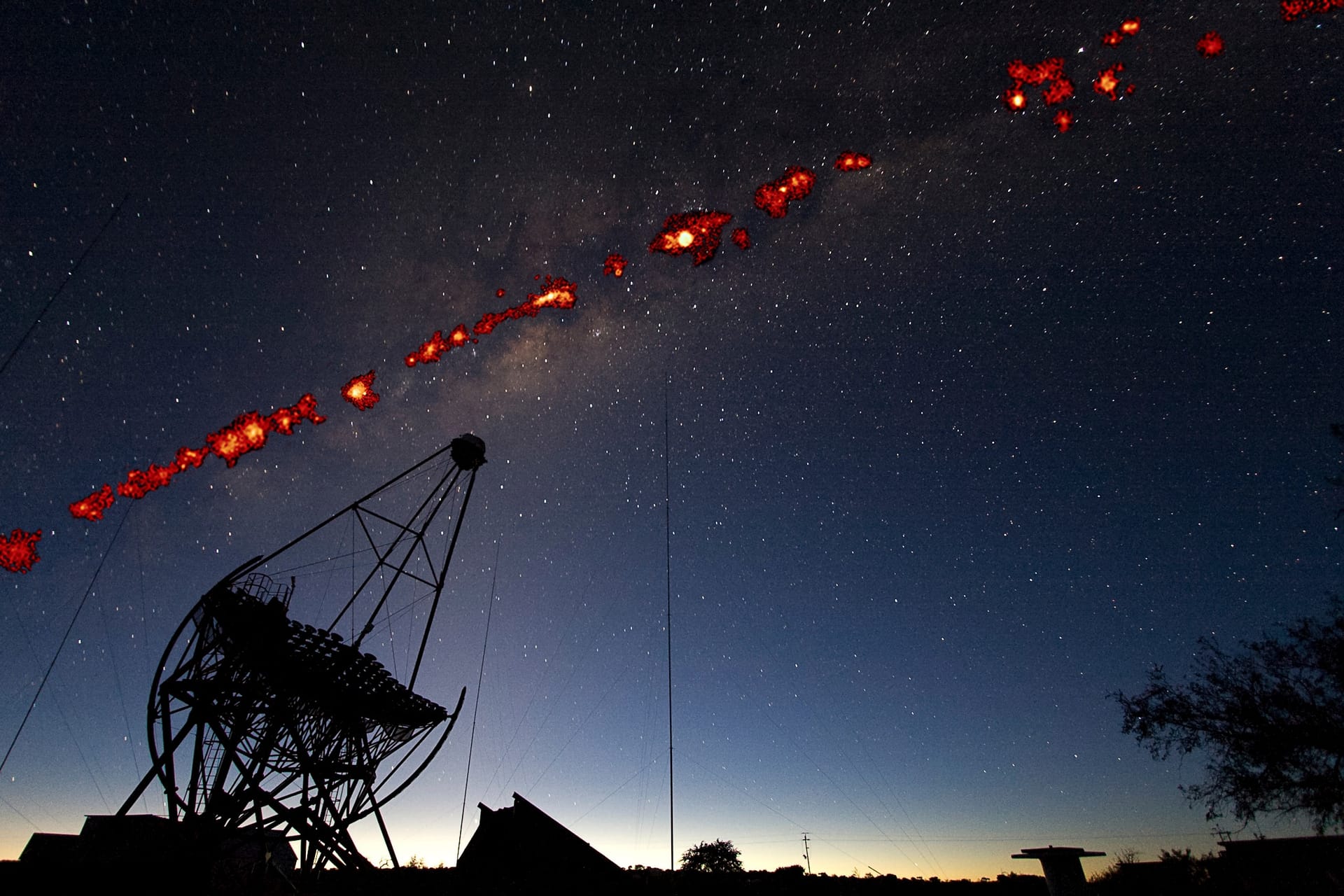 An H.E.S.S. Cherenkov telescope at night beneath the Milky Way, with the H.E.S.S. Galactic Plane Survey of very-high-energy gamma-ray sources overlaid along the galactic plane.